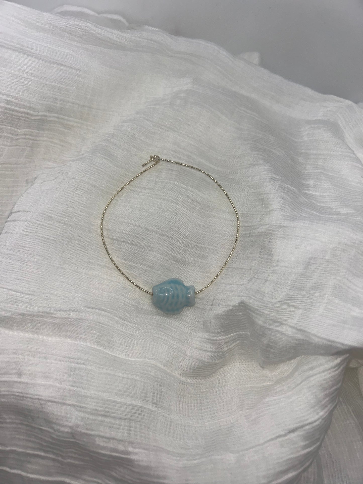 bracelet plaque or 14k torsade avec un poisson ceramine bleu clair