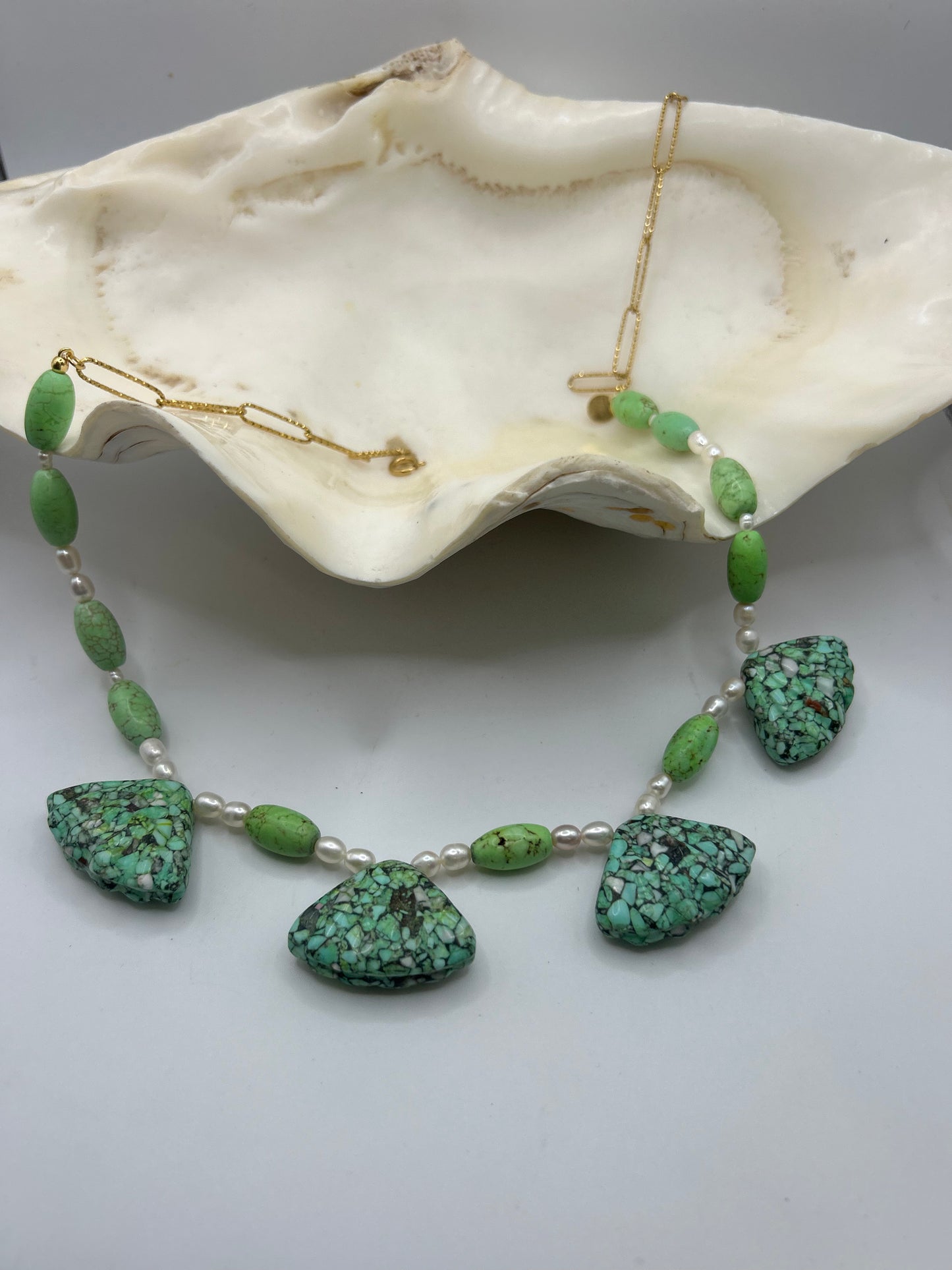 Découvrez ce collier unique en turquoise naturelle forme coquillage et perles de culture. Une création artisanale inspirée de l’océan, alliant élégance, spiritualité et énergie positive.