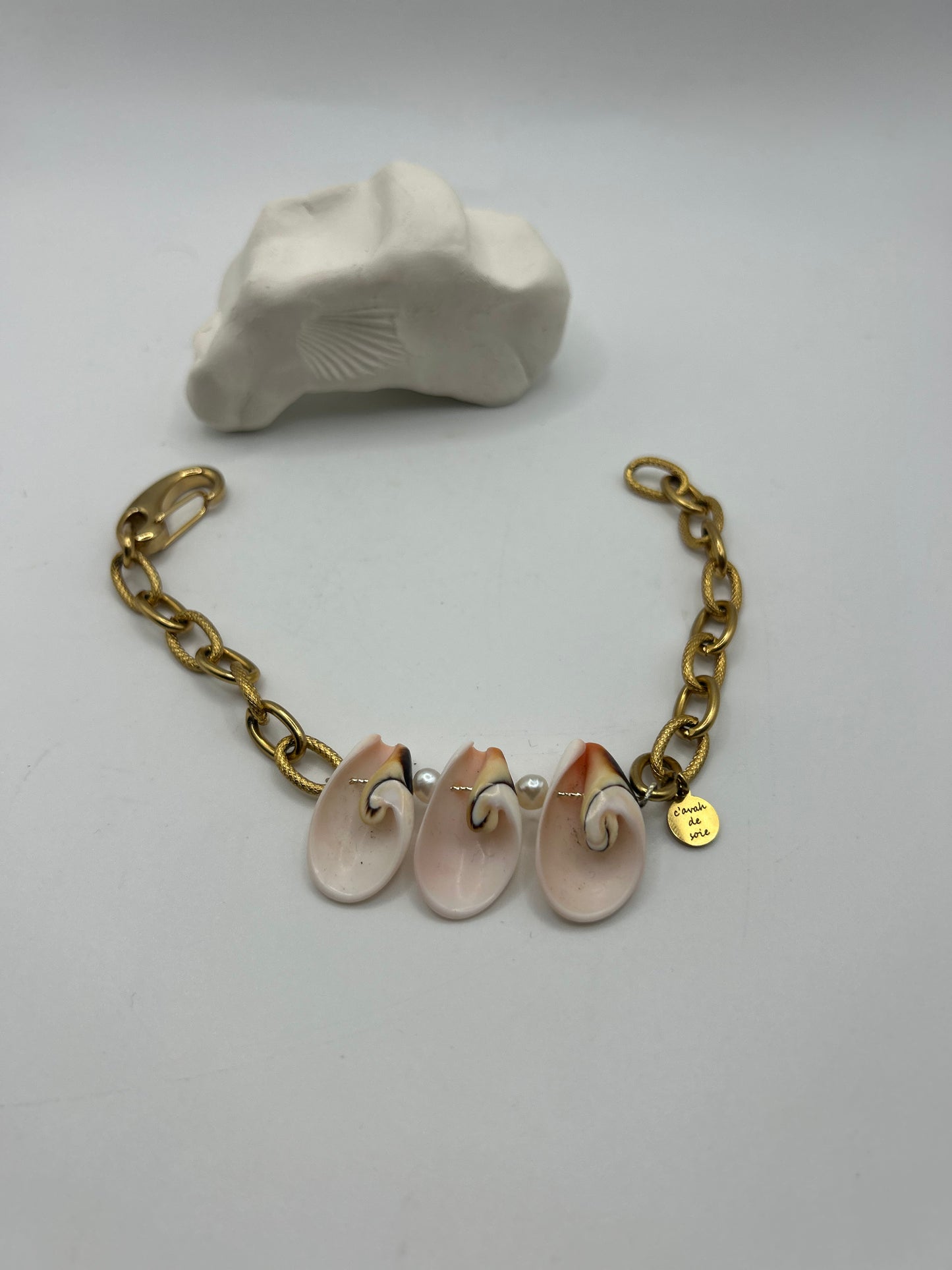 Bracelet ou chaîne de cheville en acier inoxydable orné de trois coquillages centrés, création artisanale inspirée de la mer, du style bohème chic et des trésors marins.