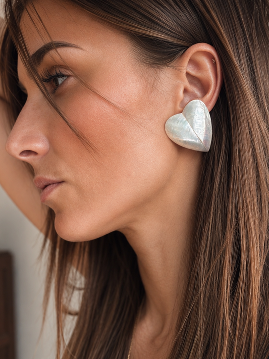 Boucles d’oreilles en forme de cœur bleu nacré avec reflets lumineux, style bohème chic et élégant.