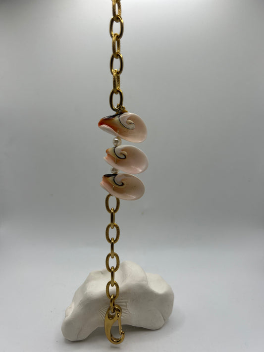 Bracelet ou chaîne de cheville en acier inoxydable orné de trois coquillages centrés, création artisanale inspirée de la mer, du style bohème chic et des trésors marins.