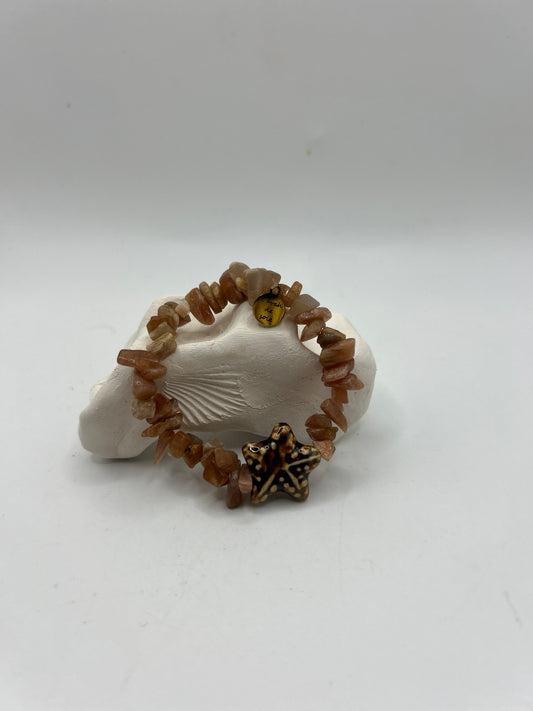 Bracelet artisanal élastique en pierre du soleil naturelle avec étoile de mer en céramique, création unique inspirée de la mer, du soleil et de l’esprit bohème méditerranéen.