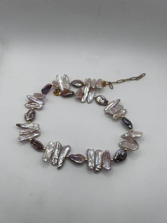 Collier en perles d’eau douce Biwa aux nuances rose, violet et nacrées, entre perles rondes et plates. Un bijou artisanal unique et délicat.
