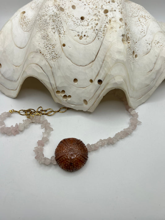 Collier artisanal en perles de coquillage, Pierre de Soleil et perles de culture avec grand coquillage central orné de perles superposées créant un effet 3D inspiré de l’océan.