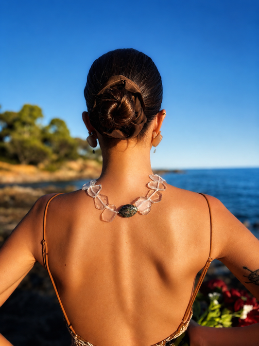Collier artisanal en quartz blanc naturel avec nacre abalone irisée aux reflets multicolores, bijou inspiré de l’océan et des matières naturelles. 

