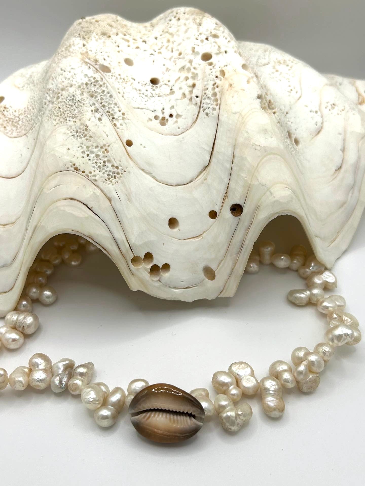 
Collier en perles de culture d’eau douce et caurie  centré au milieu 